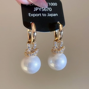 Détail de boucles d'oreilles perles plaquées or avec zircons et clous en argent 925