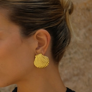 Close-up of a model wearing minimalist golden shell earrings in stainless steel