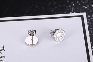 Détail macro de boucles d'oreilles octogonales arbre de vie argentées avec fermoirs