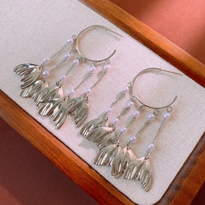 Detail of silver drop earrings with elegant pearl fringe and ginkgo leaf pendants