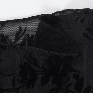 Macro detail of black mesh fabric with elegant floral flocking texture on a chiffon blouse