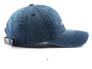 Detail of vintage navy denim baseball cap with white letter embroidery and brass buckle
