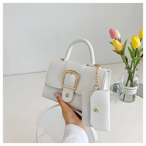 Close-up of white leather handbag with gold square buckle and matching coin purse