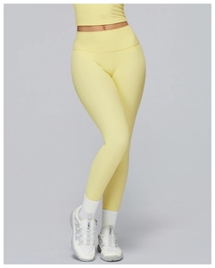 Close-up of high-waist yoga pants with sculpting seams and pale yellow matte fabric