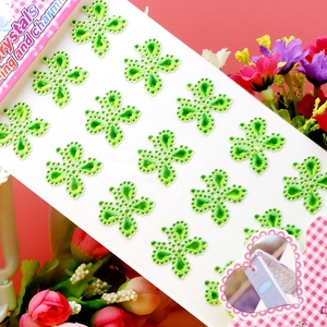 Macro shot of green clover-shaped acrylic crystal stickers for DIY phone decoration