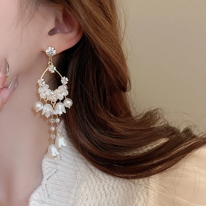 Detailed view of lily of the valley earrings with white pearls and long tassels