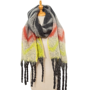 Detail of multi-color zigzag pattern scarf with chunky tassels on a studio mannequin