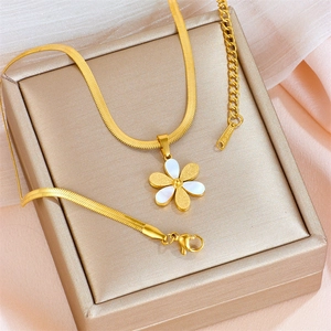 Golden flat snake chain necklace with a white daisy pendant on a silk gift box
