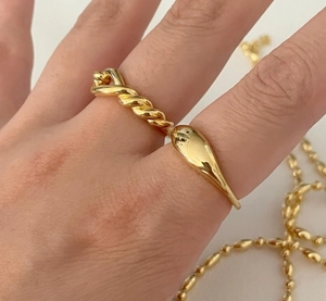 Close-up of a gold knot ring featuring twisted texture and polished drop design