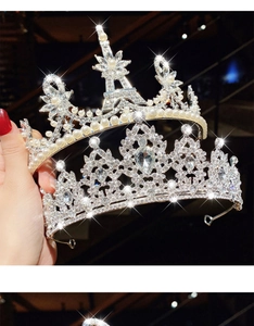 Close-up of silver tiara featuring rhinestones, faux pearls and Eiffel Tower motif