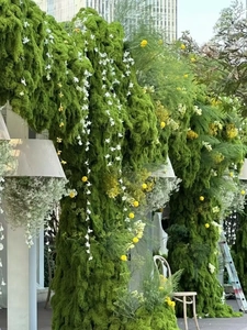 Detail of artificial green moss lawn with white orchids for luxury floral decoration