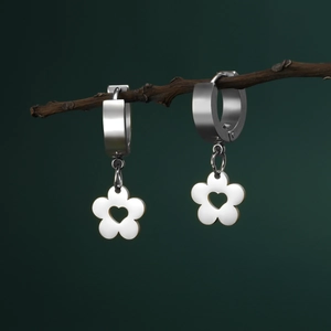Silver flower earrings with heart cutout hanging on a natural wooden branch detail