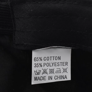 Detail of the washing label showing 65% cotton and 35% polyester blend on the black hat