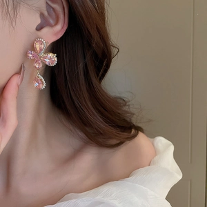 Detail of elegant pink crystal butterfly drop earring on model with gold plating