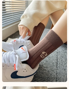 Detail of brown cotton mid-calf socks with white puppy embroidery and ribbed cuffs
