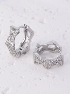 Detailed macro view of silver geometric star earrings with sparkling pavé zircons