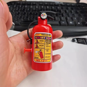 Mini fire extinguisher water gun toy for kids made of red plastic with a black hose