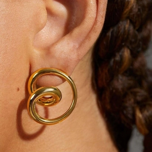 Elegant gold-plated geometric swirl earrings in stainless steel for women on a model