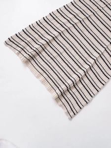 Gros plan détaillé sur la texture de la maille à rayures horizontales noir et beige