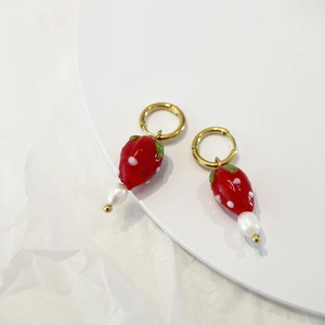 Detail view of strawberry earrings with red glass charms and white freshwater pearls
