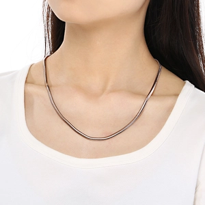 Close-up of rose gold stainless steel snake bone chain necklace on a female model neck
