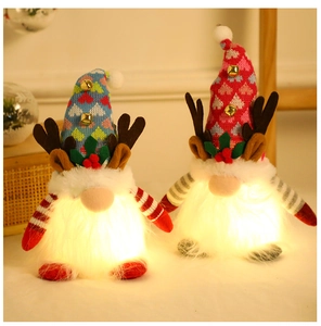 Close-up of two glowing Christmas gnomes with reindeer antlers and festive LED lights