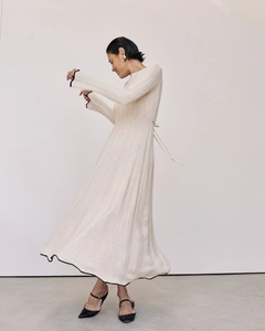 Détail de l'élégante robe en maille plissée crème avec des bords contrastés noirs chic