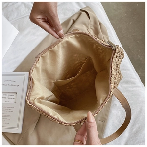 Close-up of woven tote bag interior with beige fabric lining and zipper closure