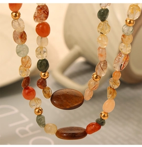 Macro detail of natural agate and rutilated quartz beads with gold-tone metal spacers