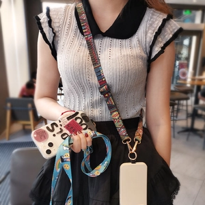 Ethnic style woven phone lanyard with adjustable crossbody strap shown on model