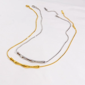 Minimalist bamboo style snake chain necklaces in gold and silver finish on white fabric