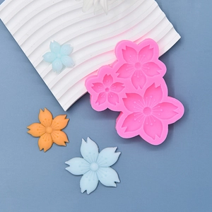 Pink silicone mold for three cherry blossom shapes with finished fondant samples