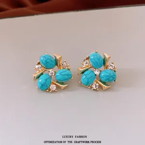 Vintage gold stud earrings with sky blue oval turquoise stones and sparkling zircons