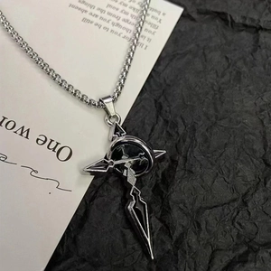 Collier gothique vintage avec croix et anneau présenté sur papier noir texturé