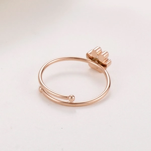 Détail d'une bague ajustable en or rose avec un motif mignon de patte en relief 3D