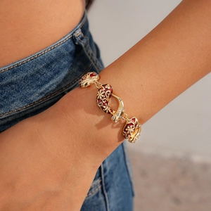 Close-up of vintage flower necklace with red enamel and zircon on model wearing jeans