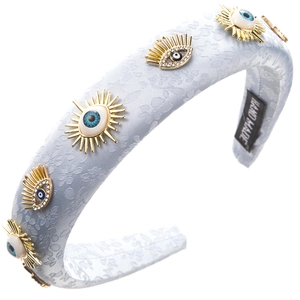 Close-up of handmade denim headband with evil eye crystal ornaments and floral texture
