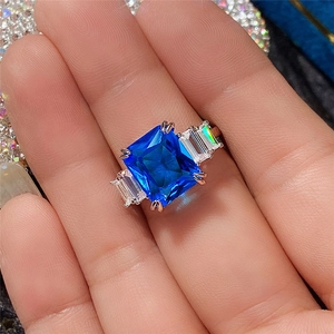 Macro shot of a rose gold ring featuring a rectangle blue zircon and side accents