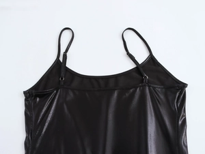 Detail of thin shoulder straps and glossy metallic fabric on a sexy black bodycon dress