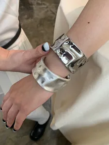 Detail of silver hammered bangles featuring matte and polished metallic texture finishes