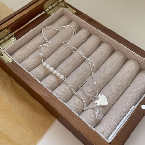 Detail of silver heart and teardrop crystal necklace with pearls in a velvet jewelry box