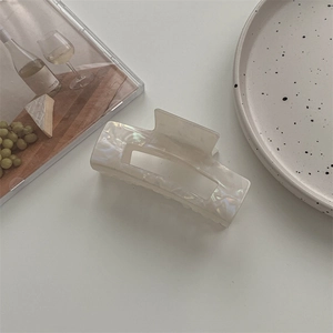 Detail der Haarklammer aus Acetat mit weißer Marmor-Textur und minimalistischem Hohlraum-Design