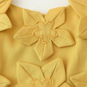 Detail von gelbem Stoff mit handgefertigter 3D-Blumenstickerei auf sexy Zweiteiler