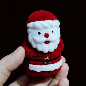 Handheld view of a Santa Claus shaped velvet jewelry box with fine red and white flocking