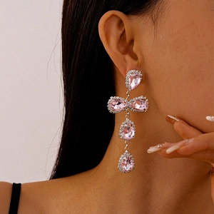 Detail of pink crystal teardrop earrings worn by model showing long tassel design