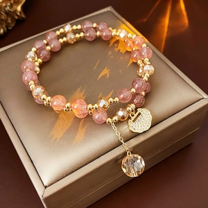 Double-layer pink beaded bracelet with gold moon charm and crystal ball on jewelry box