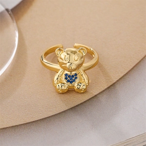 Close-up of golden bear ring featuring a blue heart rhinestone and adjustable open band