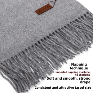 Close-up of charcoal gray wool cashmere scarf featuring soft brushed texture and long tassels