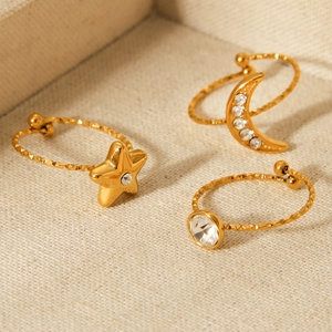 Gold stainless steel star and moon ring set with zircon stones on beige background