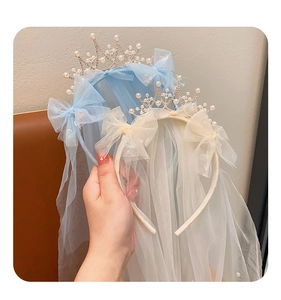 Close-up of children crown headband with tulle bow and pearls in blue and cream
